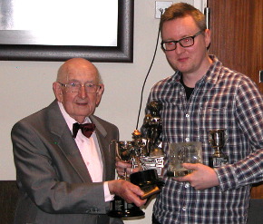 Tony with his hands full of trophies recieves the Stan Olman Award from Bernard